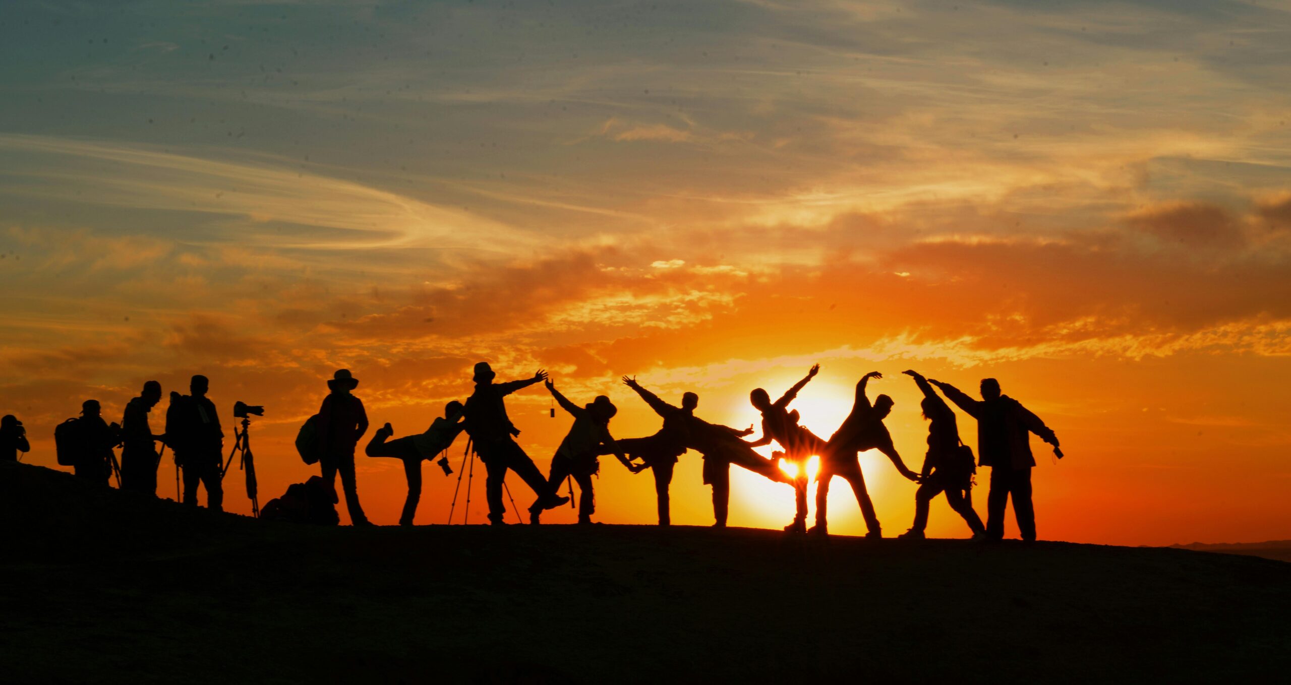 A group of friends standing on a hill at sunset, enjoying Adventure Trips for Friends.