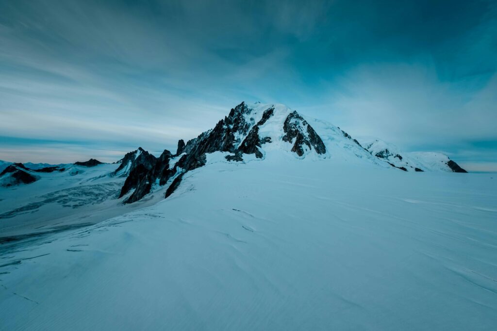 Snow-covered mountain under blue sky, a must-do activity in France.