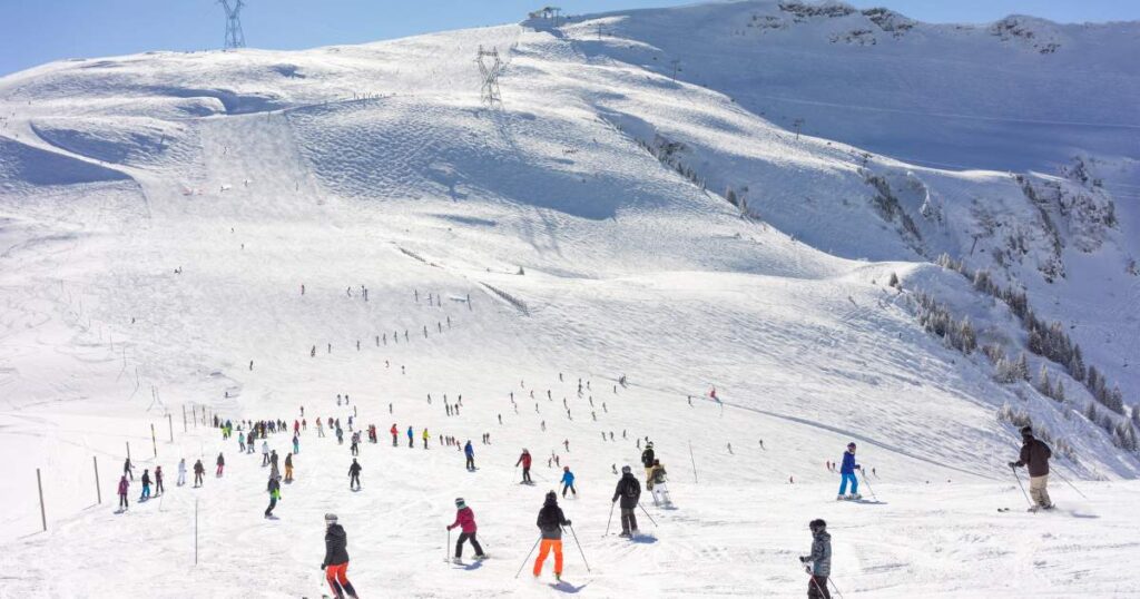 A group of skiers enjoying the snowy mountain slopes in the French Alps.