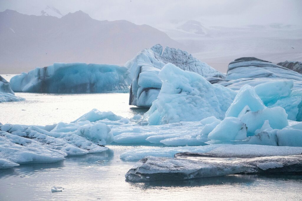 Icebergs floating in water near mountains, a must-see sight in Iceland.